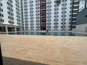 an empty courtyard in a building with tall buildings at Sirami homestay in Kampar