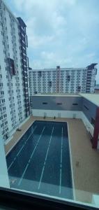 a swimming pool on top of a building with tall buildings at Sirami homestay in Kampar