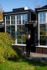 una mujer parada frente a una casa en Grend Stavern en Larvik
