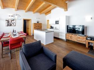 a living room with a dining table and a kitchen at Luxurious Apartment with Sauna Garage Roof Terrace in Gerlos