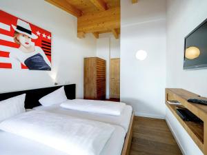 a bedroom with two beds and a tv at Luxurious Apartment with Sauna Garage Roof Terrace in Gerlos