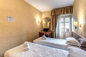 a hotel room with two beds and a mirror at Hotel Pomezia in Rome