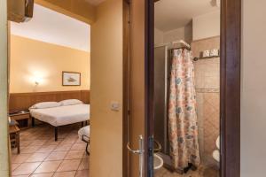 ローマにあるホテル ポメーツィアのベッド1台、バスルーム(シャワー付)が備わります。