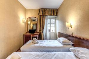 a hotel room with two beds and a mirror at Hotel Pomezia in Rome