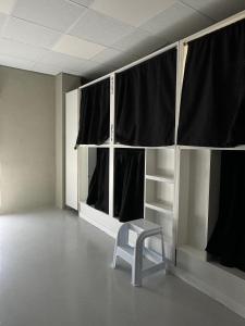 uma cadeira num quarto vazio com cortinas pretas em Naap em Valência