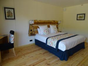 una camera con letto e pavimento in legno di Le Volcan des Sens, chambres d'hotes de luxe et SPA a Torsiac