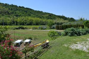 twee banken in een tuin met een heuvel op de achtergrond bij Apartma na vasi in Sečovlje