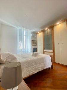 1 dormitorio con cama blanca y ventana grande en Casa Giulia La Spezia, en La Spezia