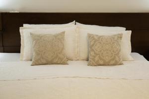 un letto bianco con 4 cuscini di Edifício Flat Hotel Congonhas a San Paolo