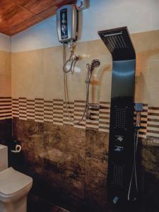 a shower in a bathroom next to a toilet at Miracle Sand Country Resort in Mawatagama
