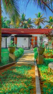 a house with two plants in front of it at Miracle Sand Country Resort in Mawatagama