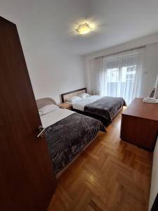 Habitación con 2 camas, escritorio y ventana. en Luks 3 apartment, en Banja Luka