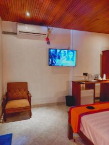 Mawatagama的住宿－Miracle Sand Country Resort，卧室配有一张床,墙上配有电视。