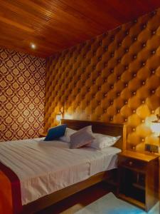 1 dormitorio con 1 cama con una gran pared acolchada en Miracle Sand Country Resort en Mawatagama