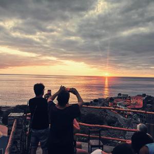 a group of people taking pictures of the sunset at Kaza Ladera in Seladinha