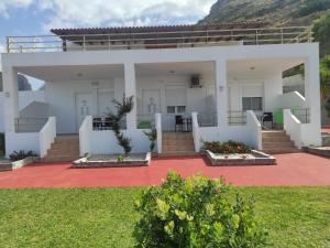 a white house with a patio and grass at Chrisanthi Studios & Apartments in Plakias