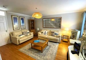 a living room with two couches and a coffee table at Beach Mews in Torquay