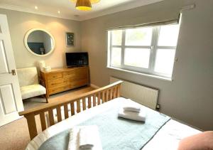 a room with a bed and a window and a mirror at Beach Mews in Torquay