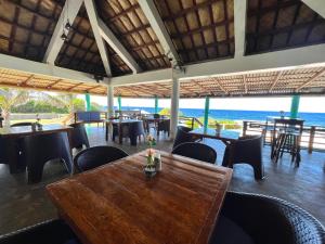 un restaurante con mesas y sillas y vistas al océano en Balay Pacifico, en Sarog