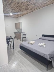ein Schlafzimmer mit einem Bett und einem Tisch sowie eine Küche in der Unterkunft Case Vacanza Marganai in Iglesias