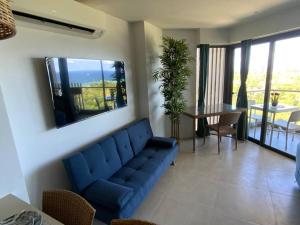 a living room with a blue couch and a table at Ma Roberta - Tambuli Resort with fast Wifi 16 Floor Studio Type in Lapu Lapu City +37 photos