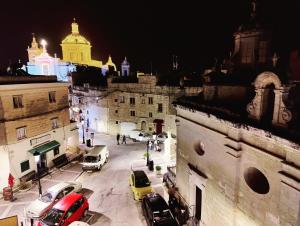 a city with cars parked on a street at night at Traditional Maltese townhouse in Rabat in Rabat