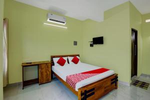 Säng eller sängar i ett rum på OYO Prasanth Holiday Inn