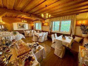jadalnia z białymi stołami i białymi krzesłami w obiekcie Panoramahotel Steirerland w mieście Kitzeck im Sausal