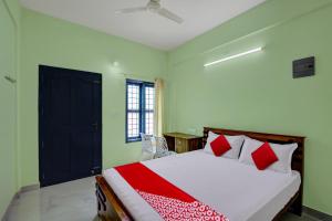 ein Schlafzimmer mit einem Bett mit roten Kissen in der Unterkunft OYO Prasanth Holiday Inn in Chegāt