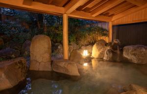 富士河口湖的住宿－Motosu Phoenix Hotel，一座有岩石和建筑的水池