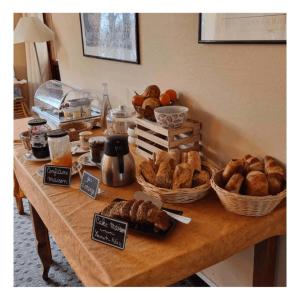 uma mesa com cestas de pão e bolos em Le Vieux Tilleul em Seyne