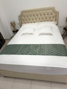 a bedroom with a large bed with a green blanket at 2 Bedroom Entire Furnished- Future Museum & Trade Center in Dubai