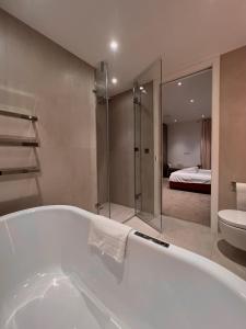 a bathroom with a bath tub and a bedroom at 2Bedroom Apartment in Central of London in London