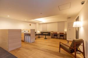 eine offene Küche und ein Wohnzimmer mit einem Tisch und Stühlen in der Unterkunft Shin-Osaka Station Hotel in Osaka