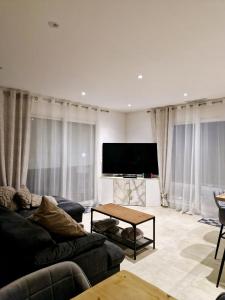 a living room with a couch and a tv at Nice, Magnifique villa vue mer avec piscine in Nice