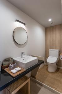 Kagamino的住宿－奧津溫泉米屋俱樂部旅館，一间带水槽、卫生间和镜子的浴室