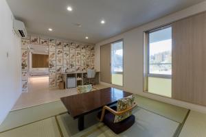 Kagamino的住宿－奧津溫泉米屋俱樂部旅館，一间带木桌和椅子的用餐室