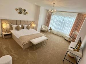 een slaapkamer met een groot bed en een kroonluchter bij Hotel Queen Vera in Mamaia