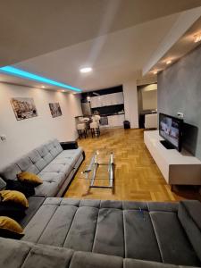 Una gran sala de estar con un sofá y un televisor. en Luks 3 apartment, en Banja Luka 59 fotos más