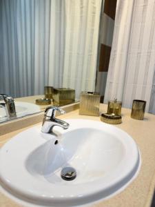 lavabo blanco en el baño con espejo en 2 Bedroom Entire Furnished- Future Museum & Trade Center en Dubái