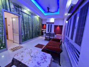 a living room with a table and a couch at Hotel Ellora Cooch Behar in Koch Bihār