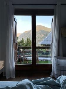 1 dormitorio con ventana y vistas a la montaña en Ca de Mariona en Boí apartamento con terraza en Bohí