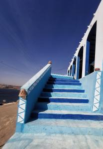 un conjunto de escaleras azules que conducen a un edificio en Asilah kato nubian guest house, en Asuán