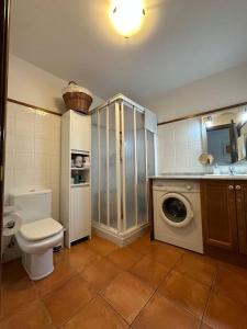 a bathroom with a toilet and a washing machine at Ca de Mariona en Boí apartamento con terraza in Bohí