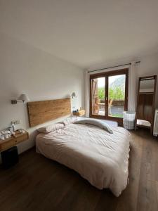 Un dormitorio con una cama grande y una ventana en Ca de Mariona en Boí apartamento con terraza, en Bohí