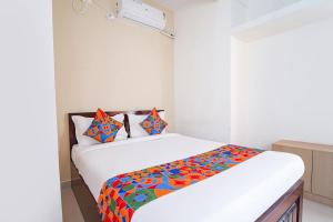 Un dormitorio con una cama con una manta de colores. en FabHotel SS Suites en Bangalore