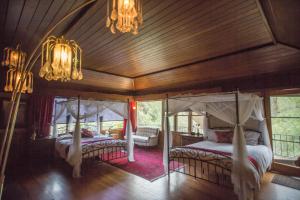 a bedroom with two beds and a wooden ceiling at Quiet Mind Lodge, Spa & Retreat Sequoias in Kernville