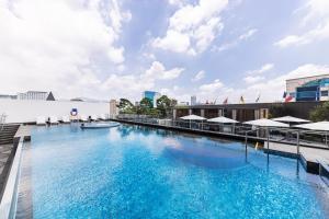 a large swimming pool with blue water at The Ambassador Seoul - A Pullman Hotel in Seoul