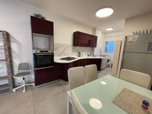 a kitchen with a table and a kitchen with a refrigerator at SVW Apartment on the Beach in Netanya