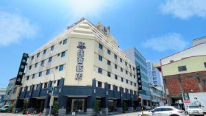 Delton Hotel في كاوشيونغ: مبنى ابيض كبير على شارع المدينة